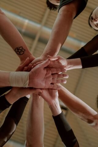 Group of people joining hands together representing a health sharing community